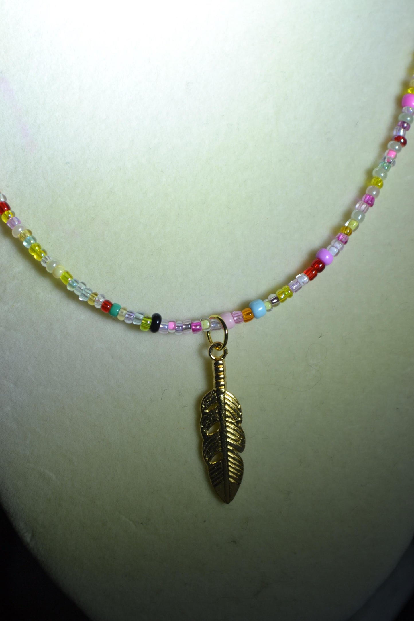 Multicolor glass bead necklace. Feather pendant