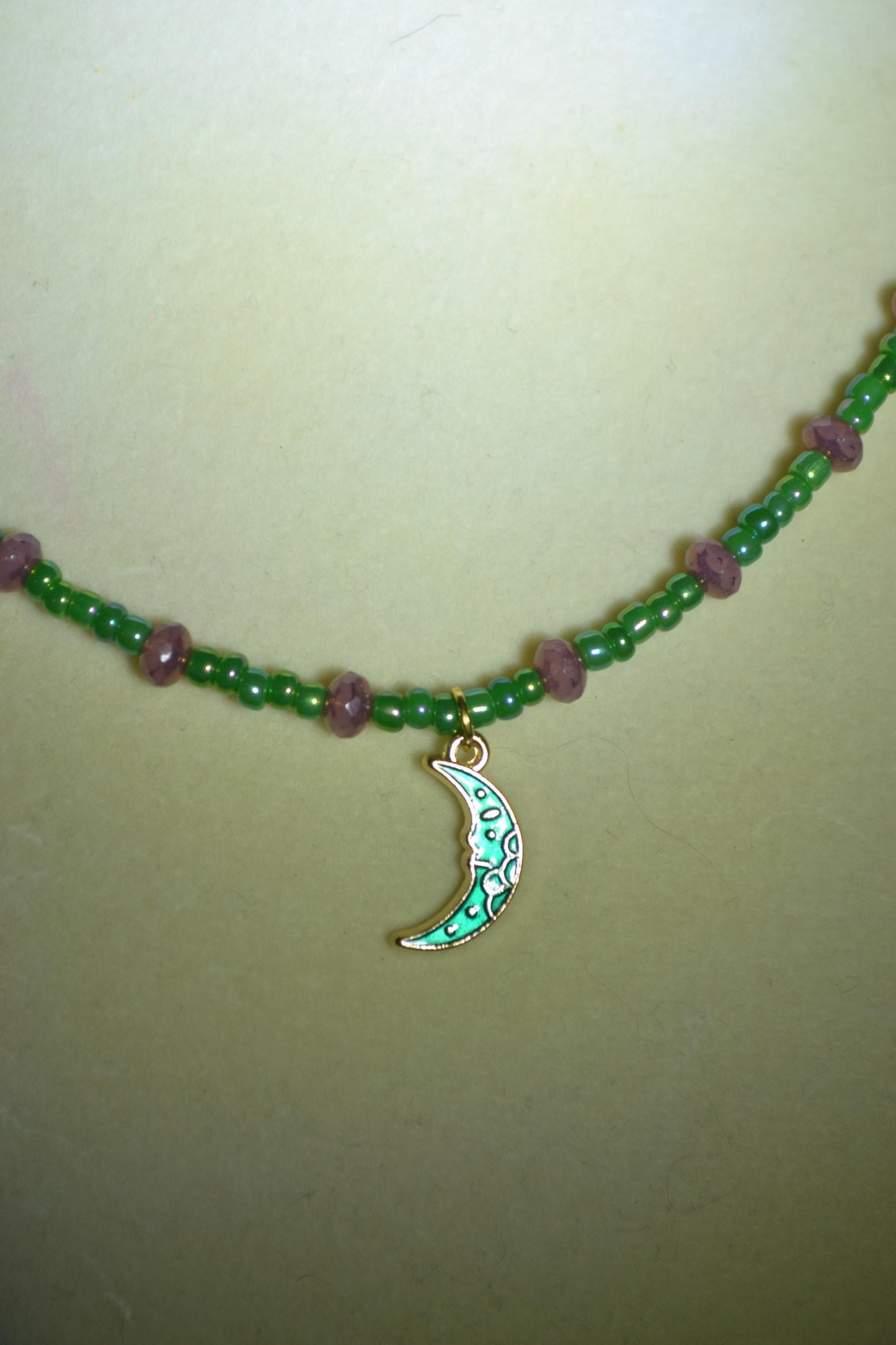 Green moon pendant glass bead necklace. Purple and green