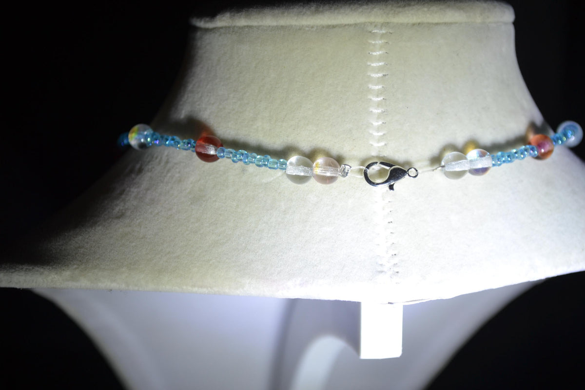 Silver Manatee pendant glass bead necklace. Blue and reds