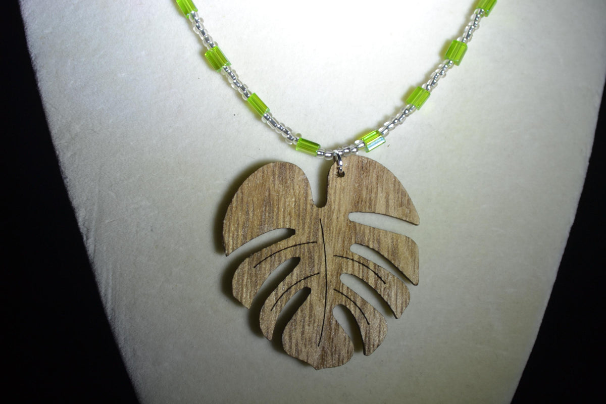 Wooden Monstera pendant glass bead necklace. Green and silver
