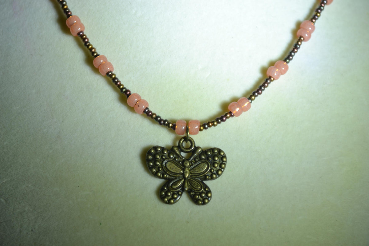 Bronze butterfly pendant glass bead necklace. Bronzes and coral
