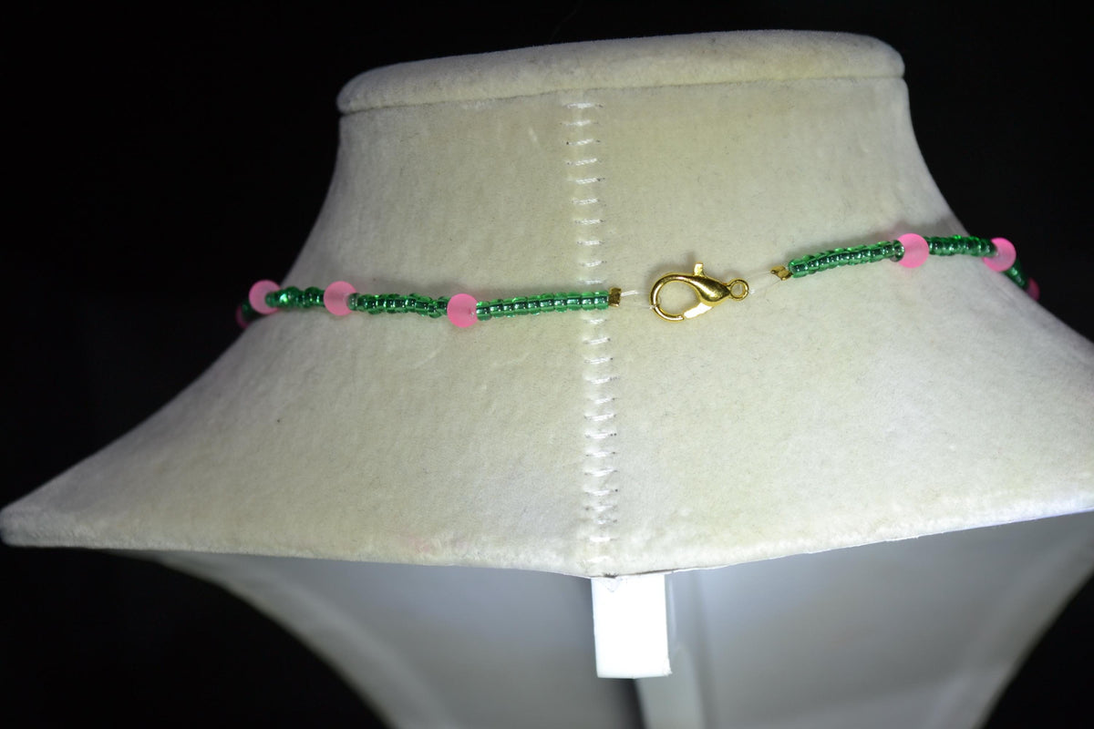 Gold Marijuana Leaf pendant glass bead necklace. Green and frosted pink
