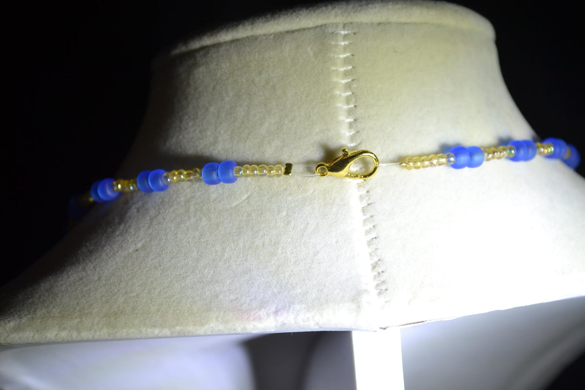 Gold Cowrie shell pendant glass bead necklace. Frosted blue and sand