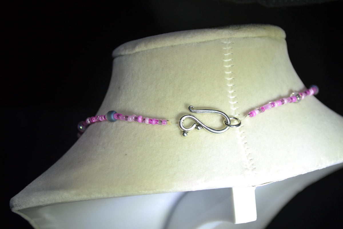 Silver Playboy pendant glass bead necklace. Mixed pinks