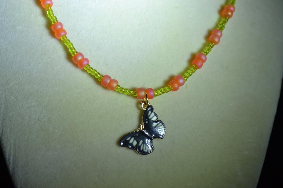 Black butterfly pendant glass bead necklace. Green and coral