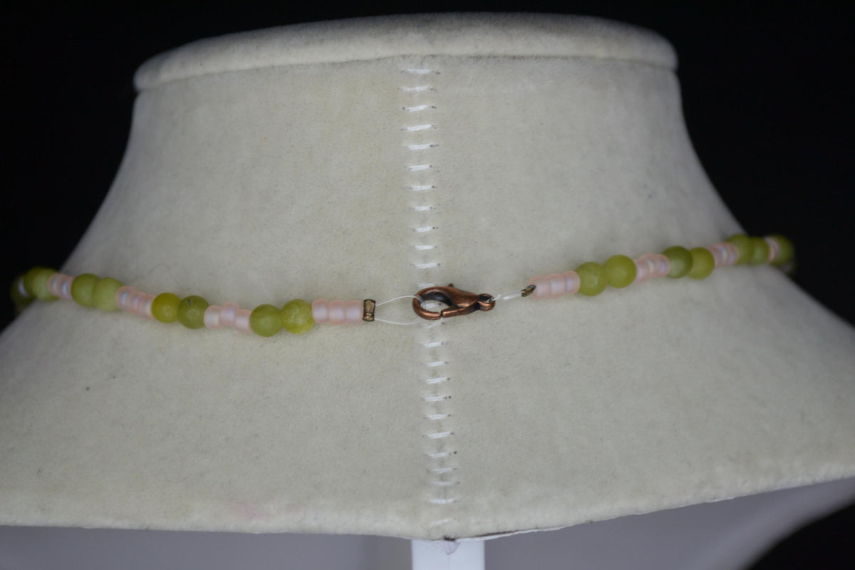 Bronze monstera pendant glass bead necklace. Jade and frosted pink