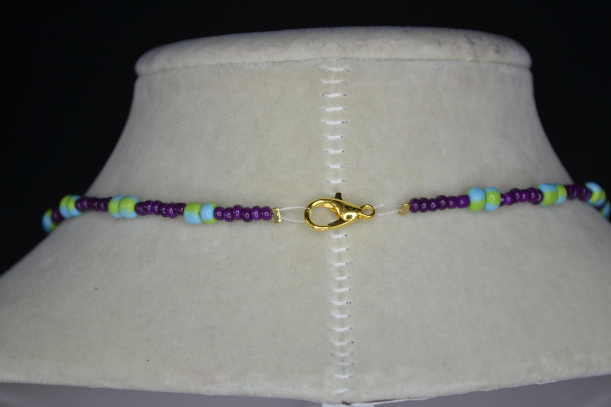 Gold Hamsa pendant glass bead necklace. Dark violet, blue, and green