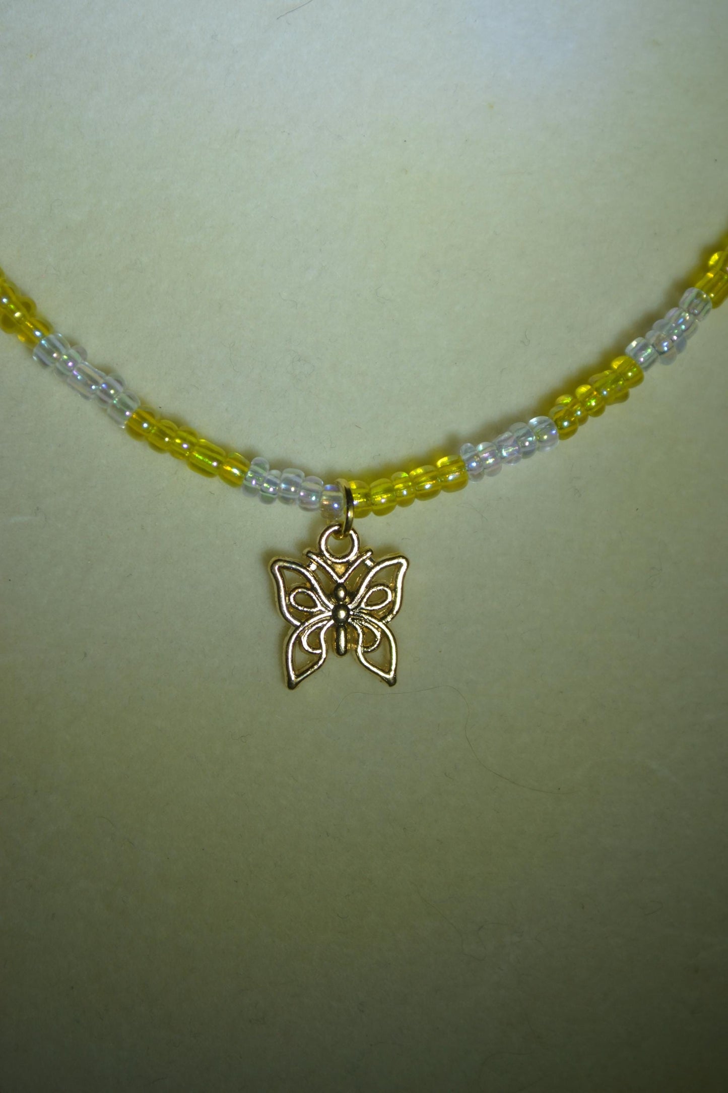 Butterfly pendant glass bead necklace. Yellow and iridescent