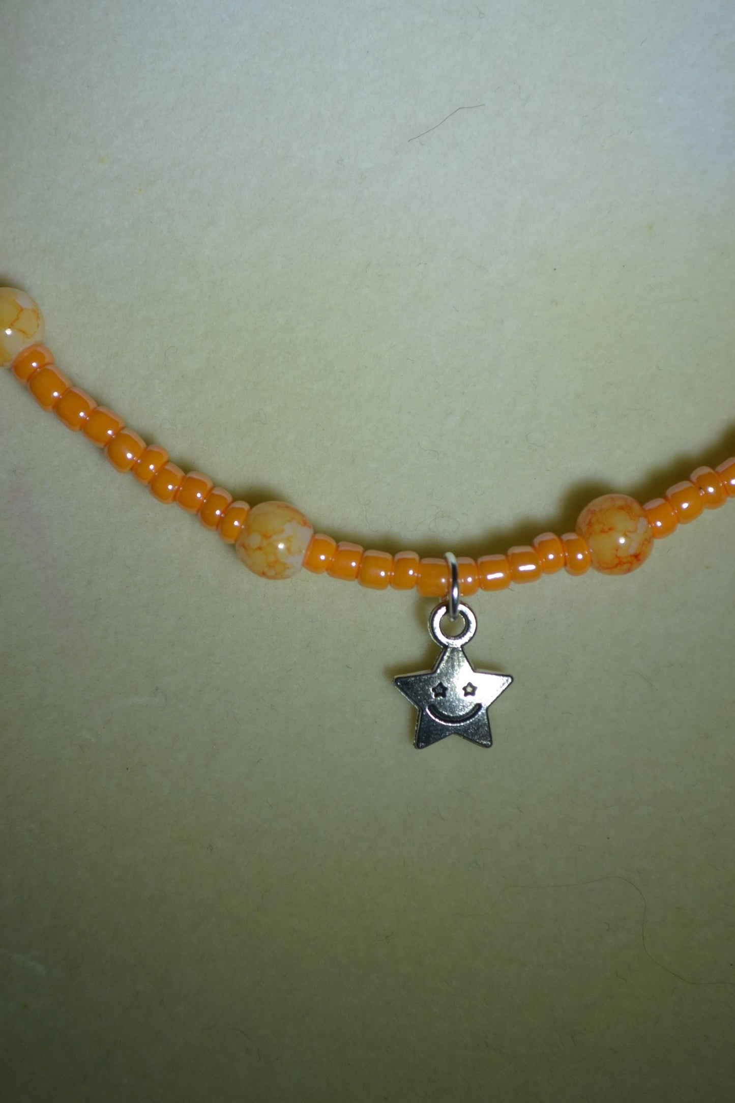 Smiling star pendant glass bead necklace. Mixed oranges