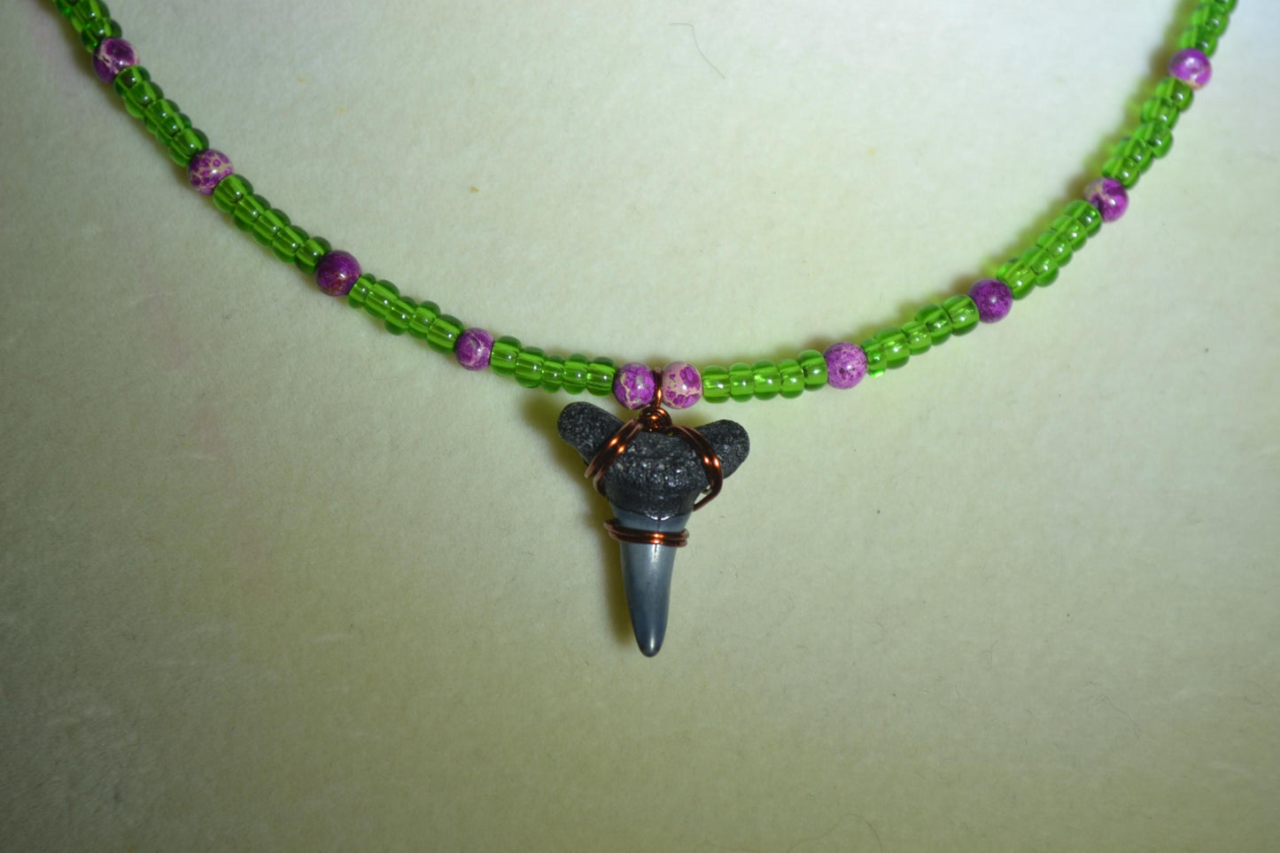 Wire wrapped sharks tooth beaded necklace. Purple and green