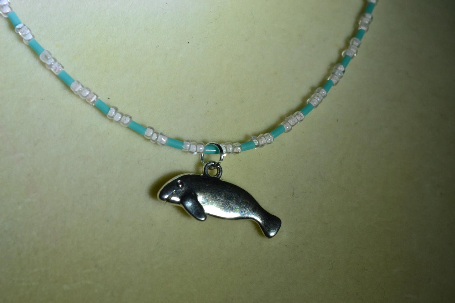 Manatee pendant glass bead necklace. Blue and white