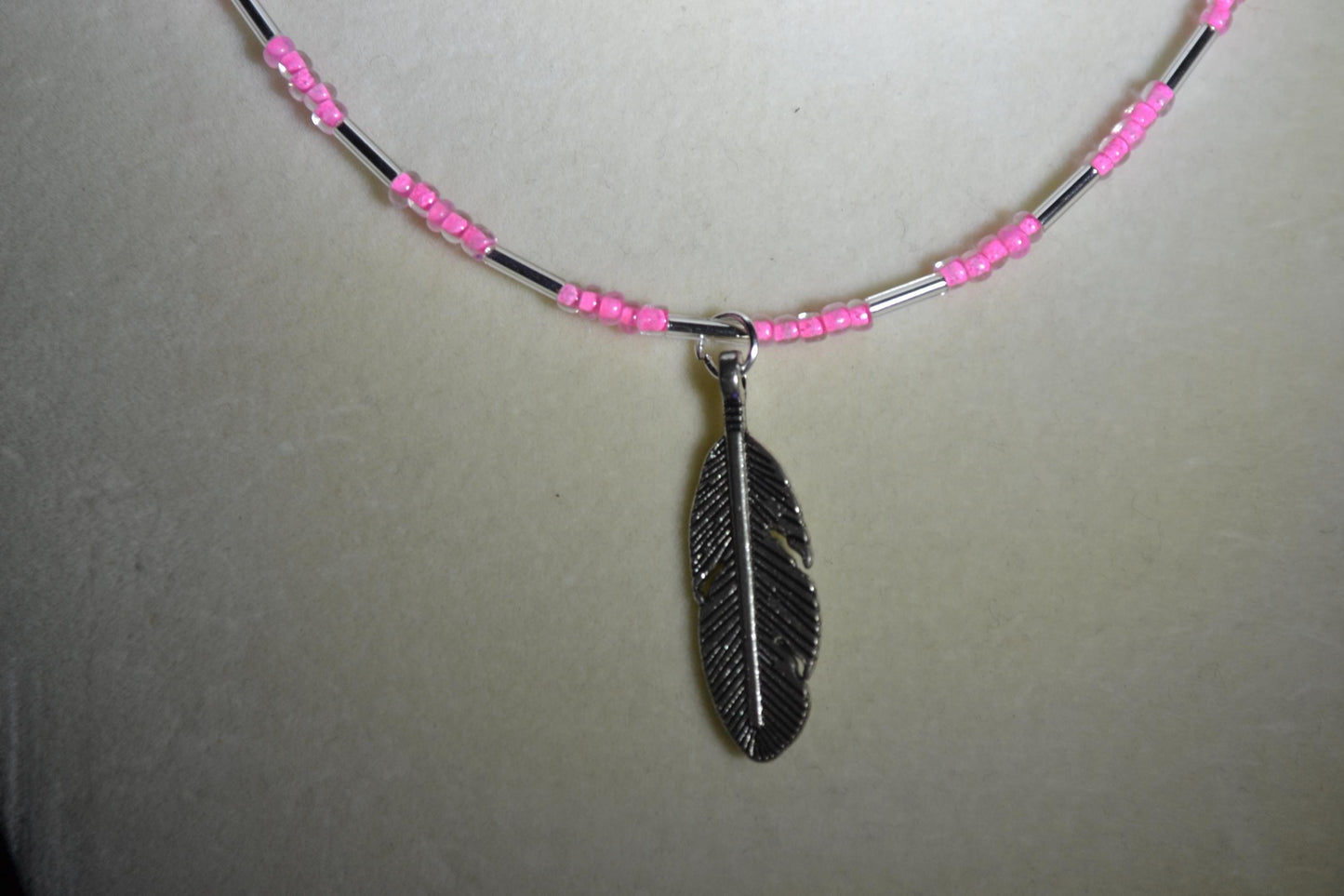 Feather pendant glass bead necklace. Pink and silver