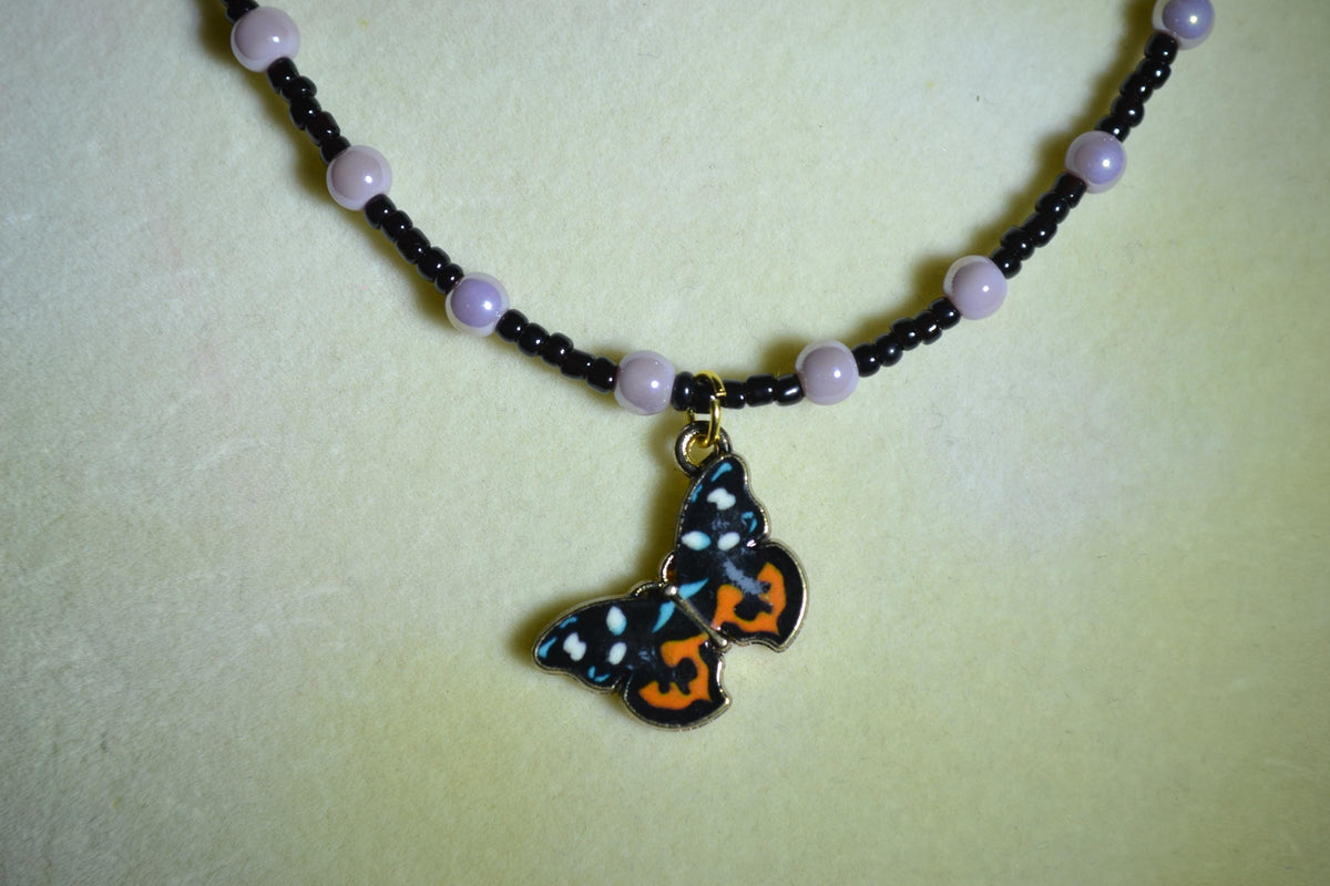Butterfly pendant glass bead necklace. Purple and black