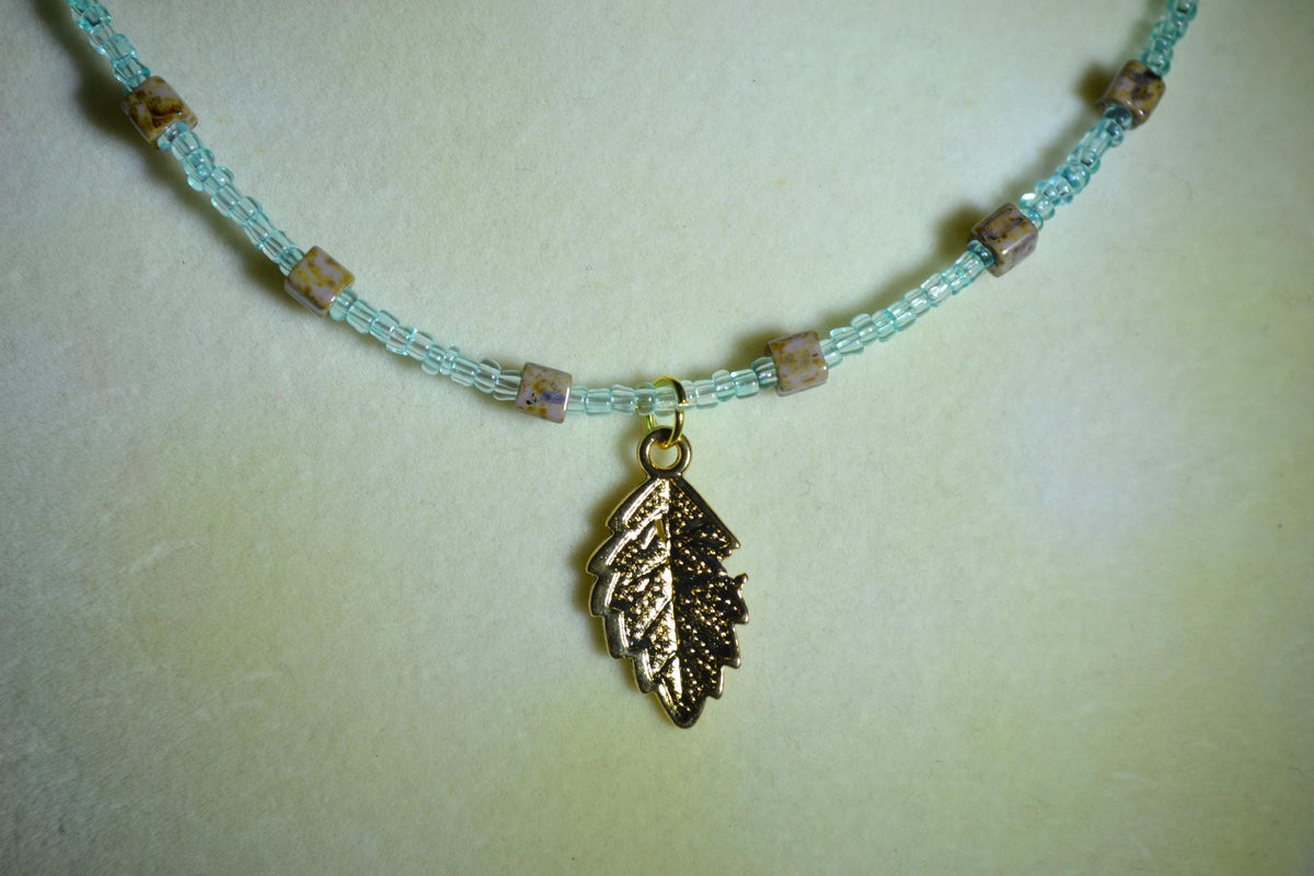 Feather pendant glass bead necklace. Teal and natural stone