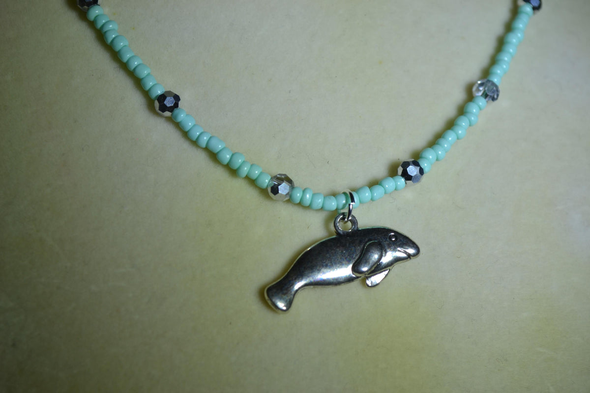 Silver Manatee pendant glass bead necklace. Aqua and silver