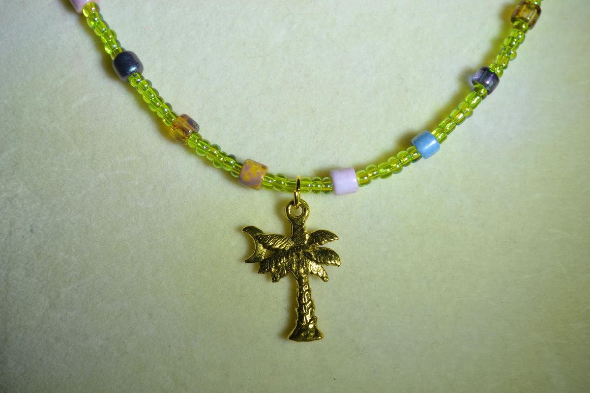 Gold Palm pendant glass bead necklace. Green and rainbow