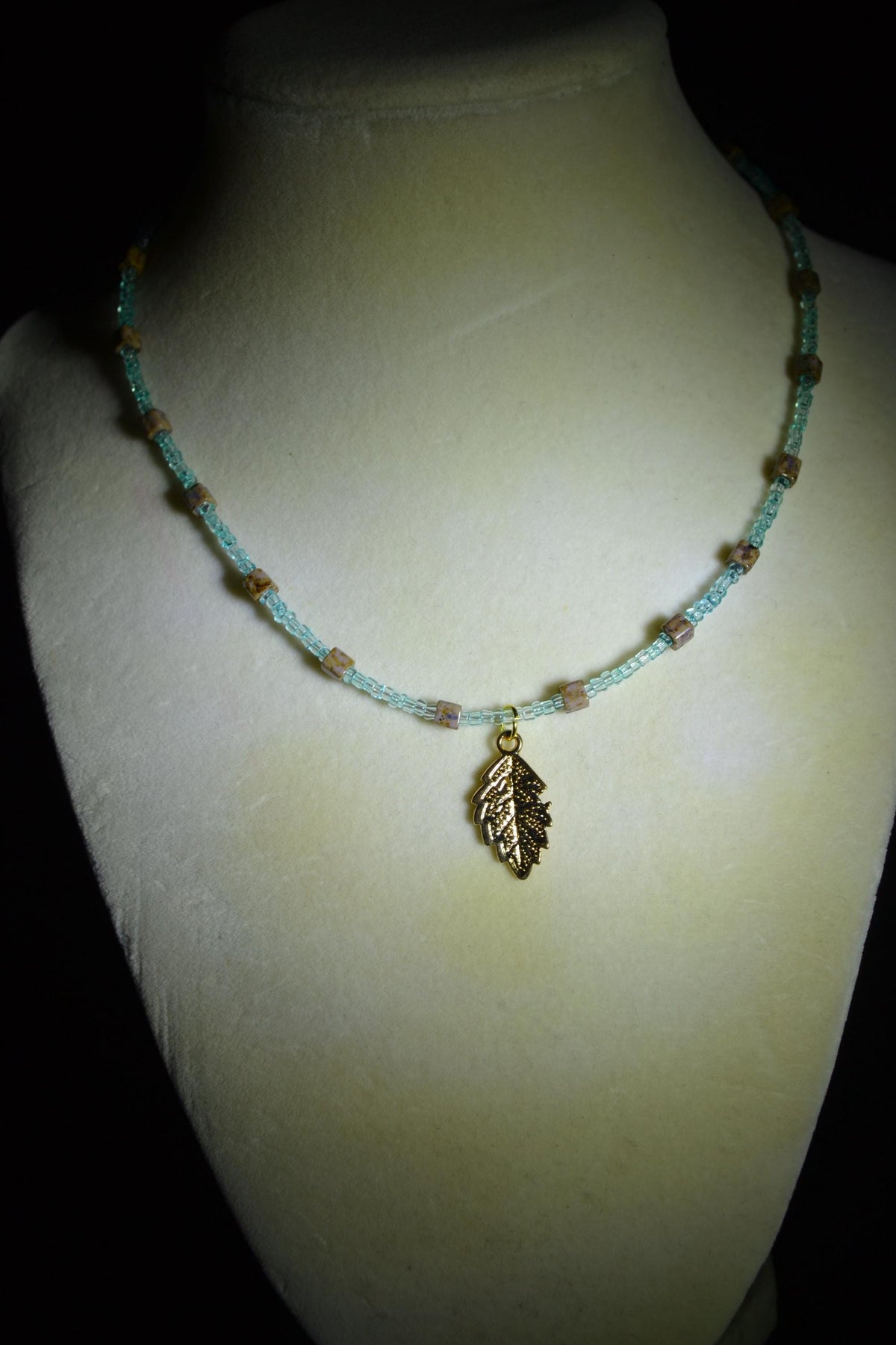 Feather pendant glass bead necklace. Teal and natural stone