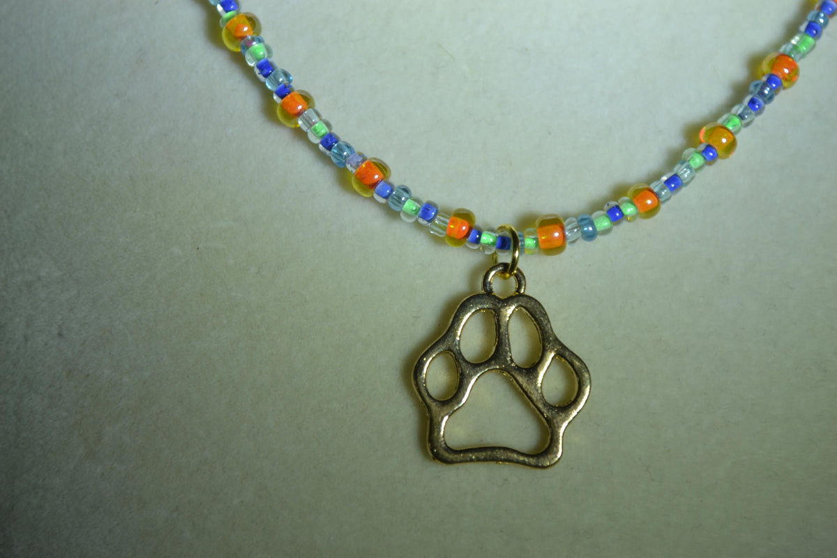 Gold Paw print pendant glass bead necklace. Orange, green, and blue