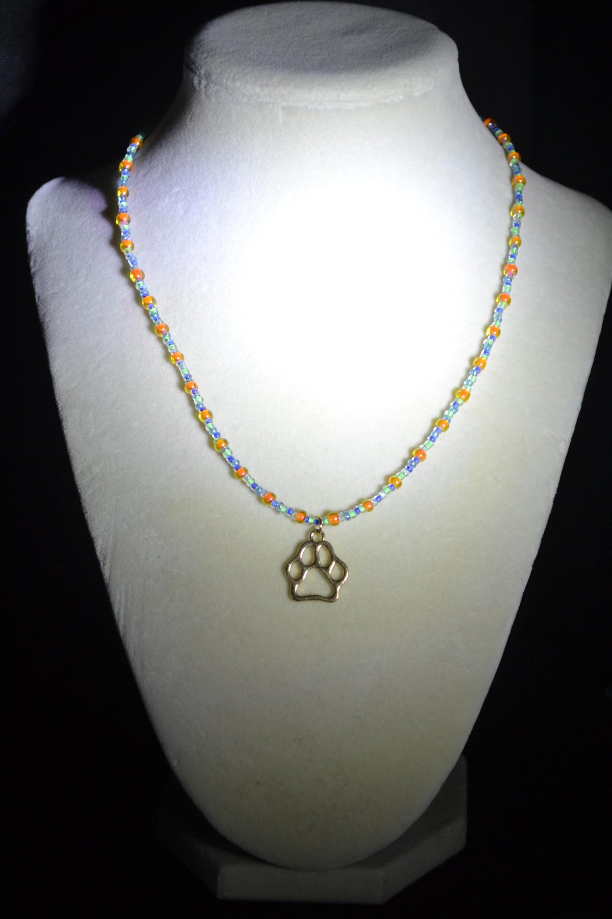 Gold Paw print pendant glass bead necklace. Orange, green, and blue