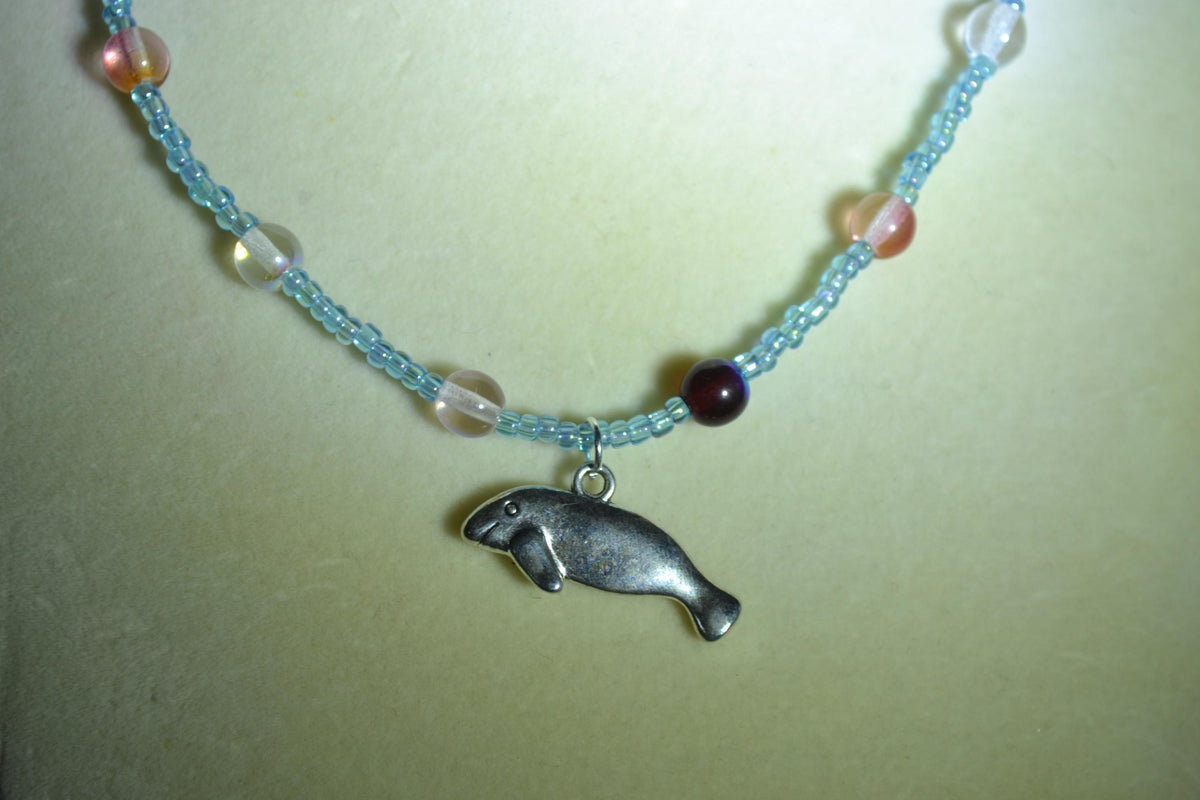 Silver Manatee pendant glass bead necklace. Blue and reds