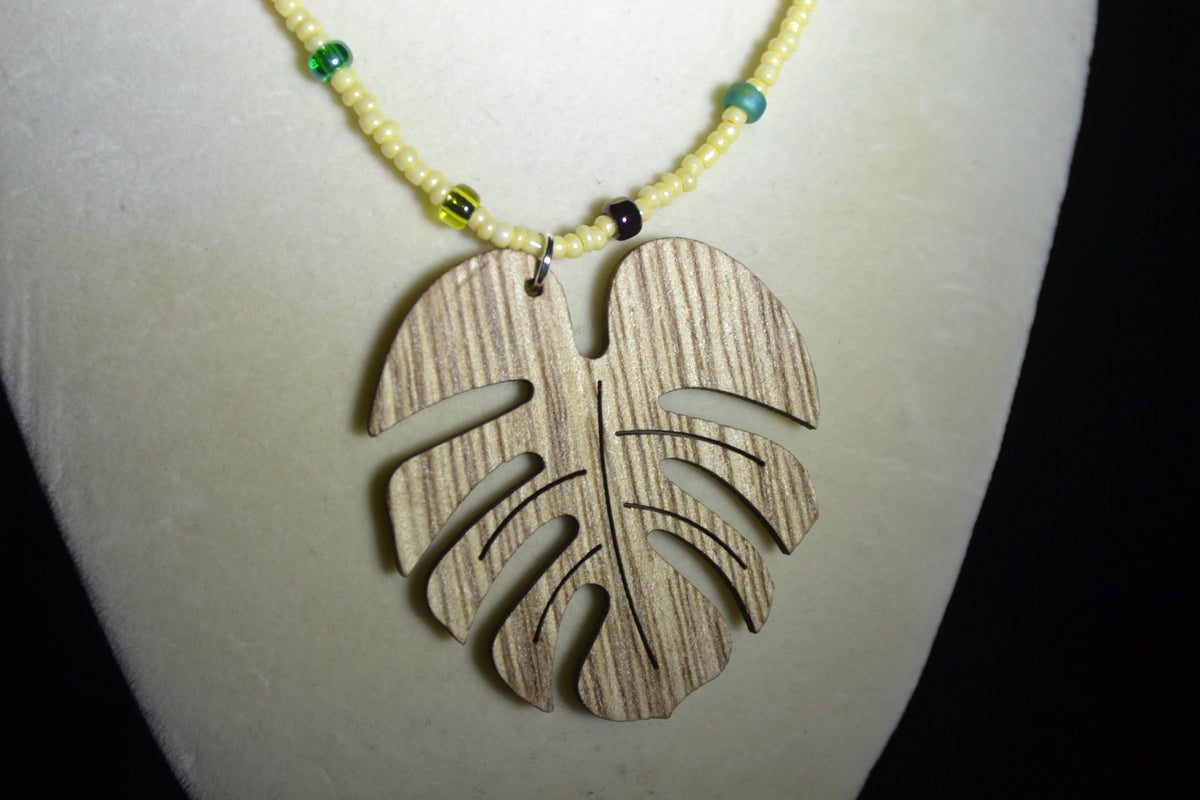 Wooden Monstera pendant glass bead necklace. Yellow & mixed greens