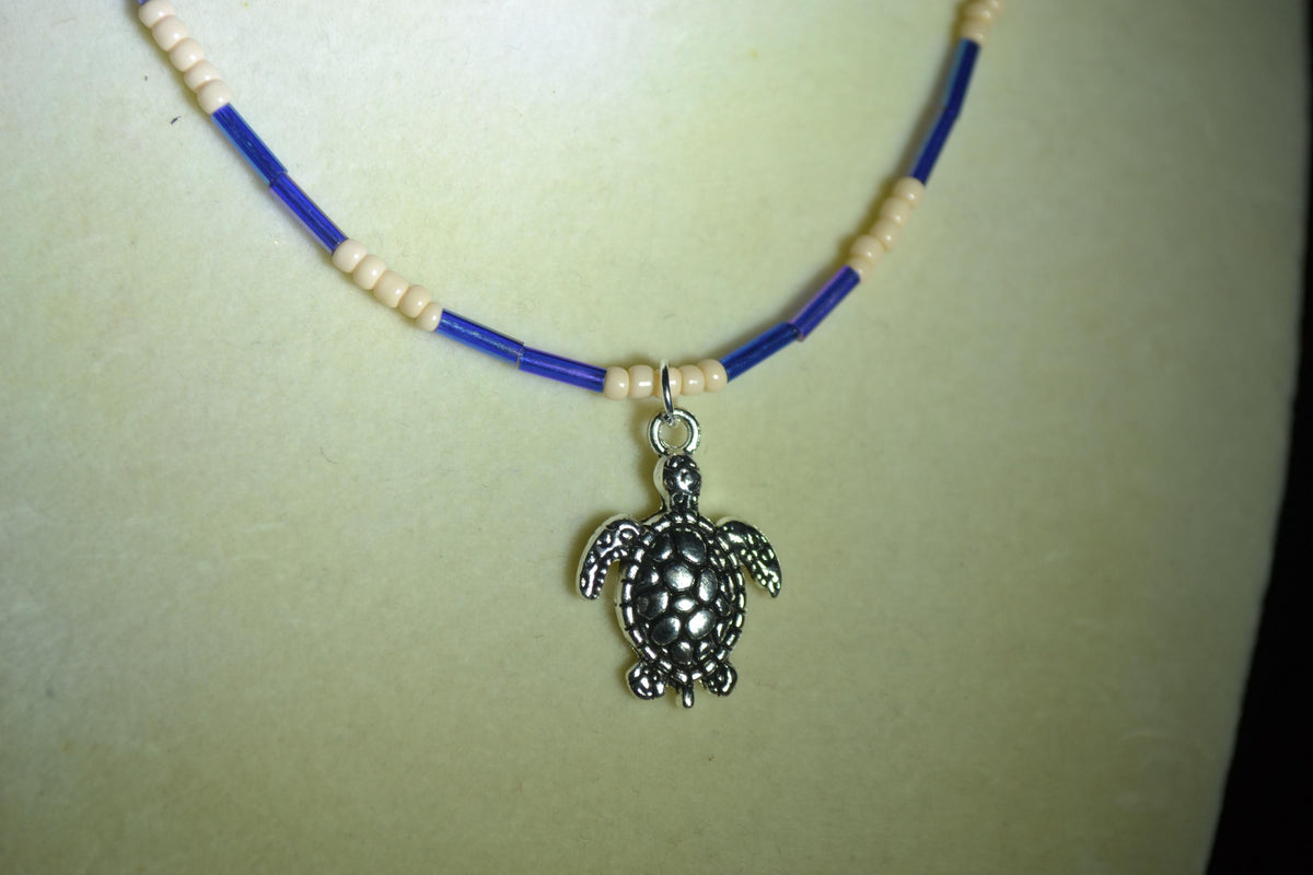 Silver turtle pendant glass bead necklace. Iridescent blue & sand