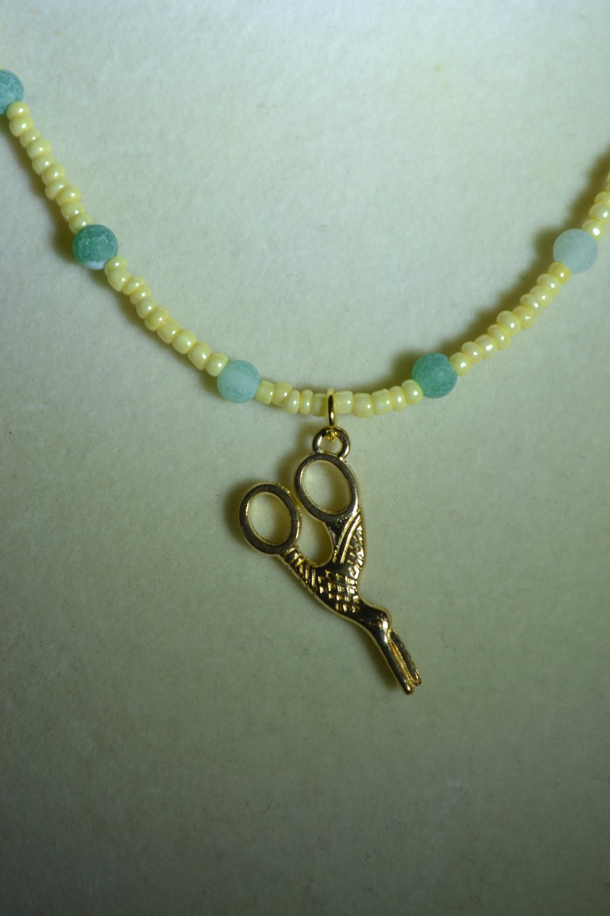 Gold scissor pendant glass bead necklace. Yellow and jade