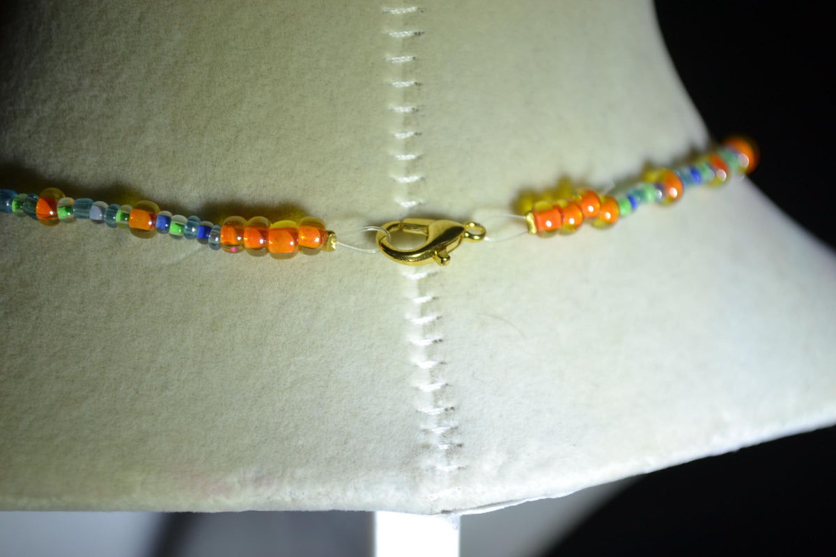 Gold Paw print pendant glass bead necklace. Orange, green, and blue