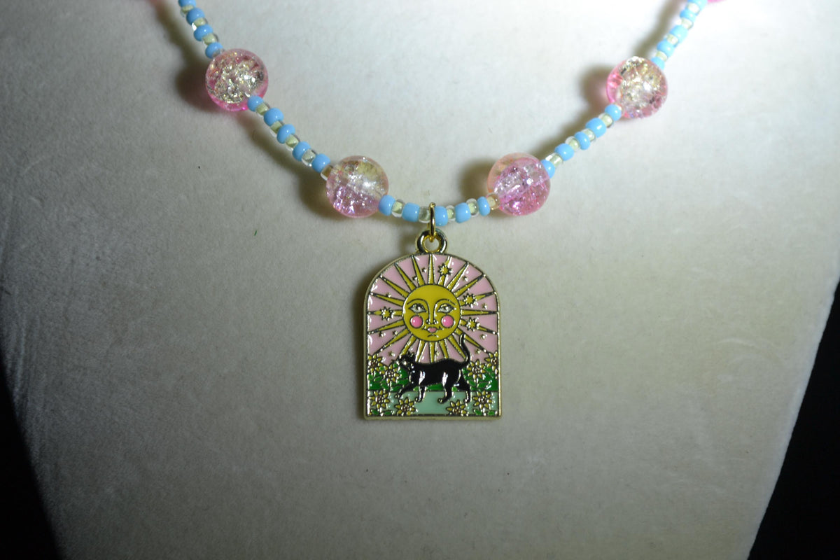 Black cat & sun pendant glass bead necklace. Blue, white, yellow, and pink