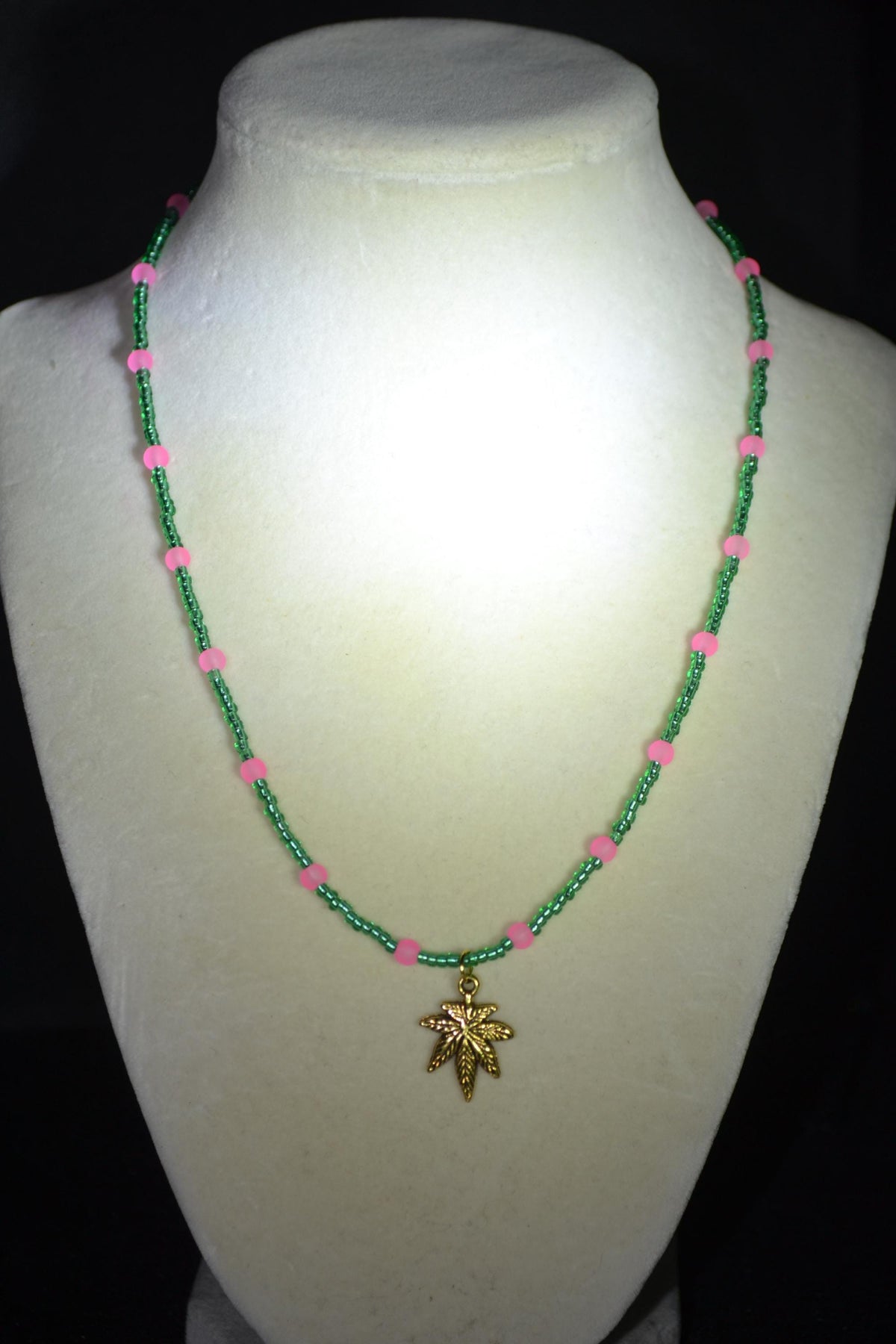 Gold Marijuana Leaf pendant glass bead necklace. Green and frosted pink