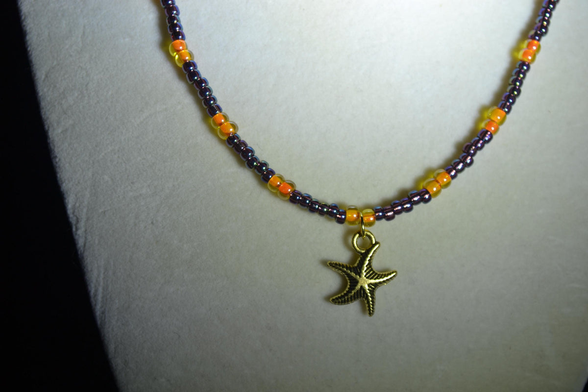 Gold Starfish pendant glass bead necklace. Amethyst and orange
