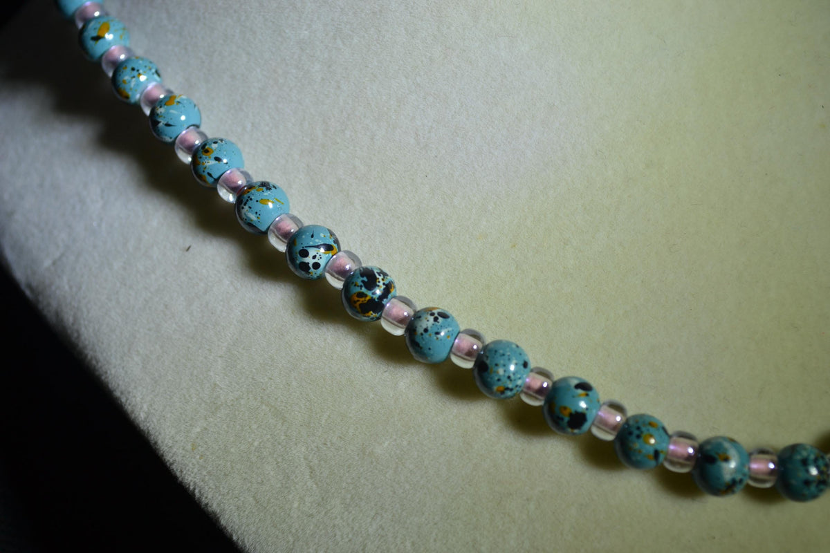 Iridescent philodendron pendant glass bead necklace. Turquoise and pink