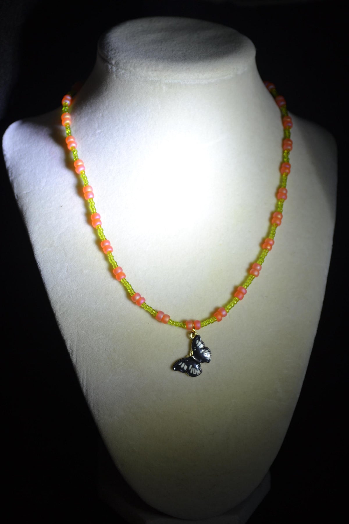 Black butterfly pendant glass bead necklace. Green and coral