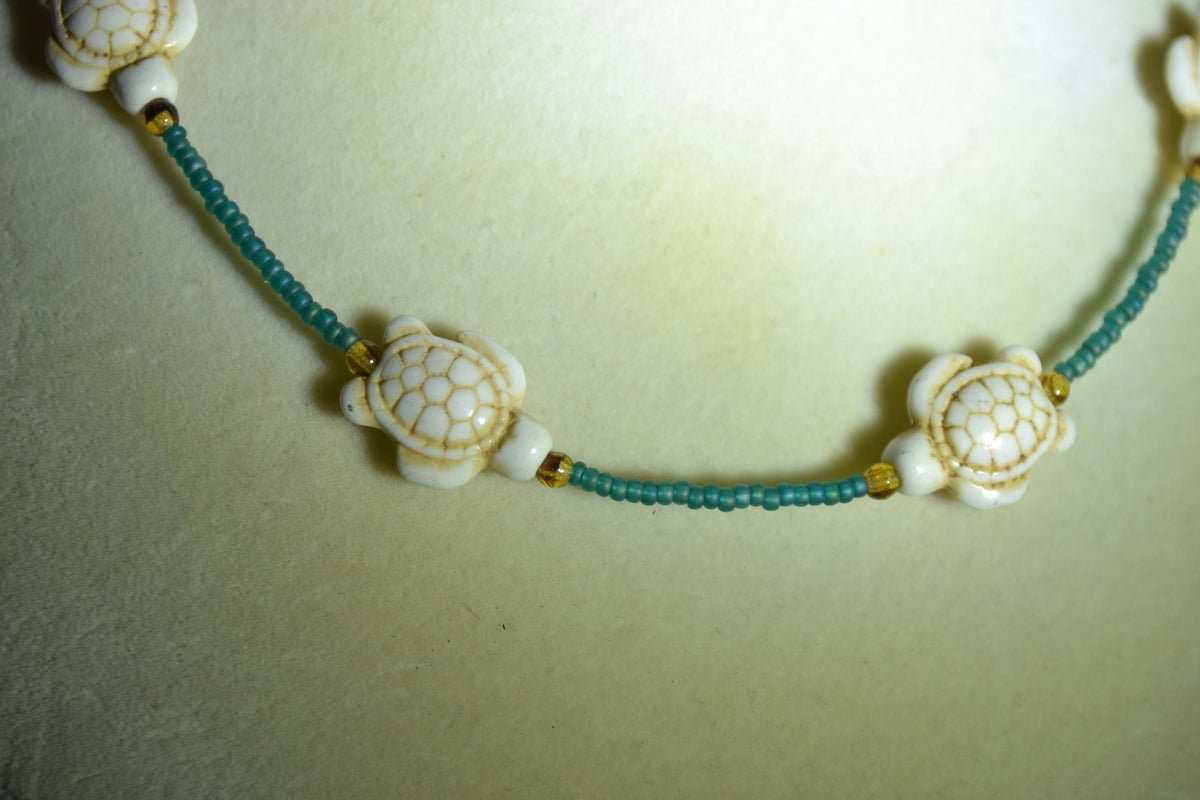 Multicolor glass bead necklace. White turtles, teal, and brown tortoise