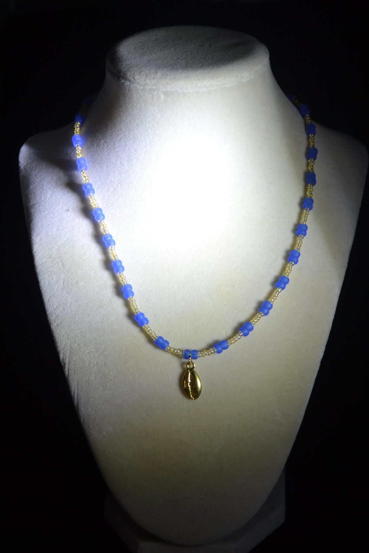 Gold Cowrie shell pendant glass bead necklace. Frosted blue and sand