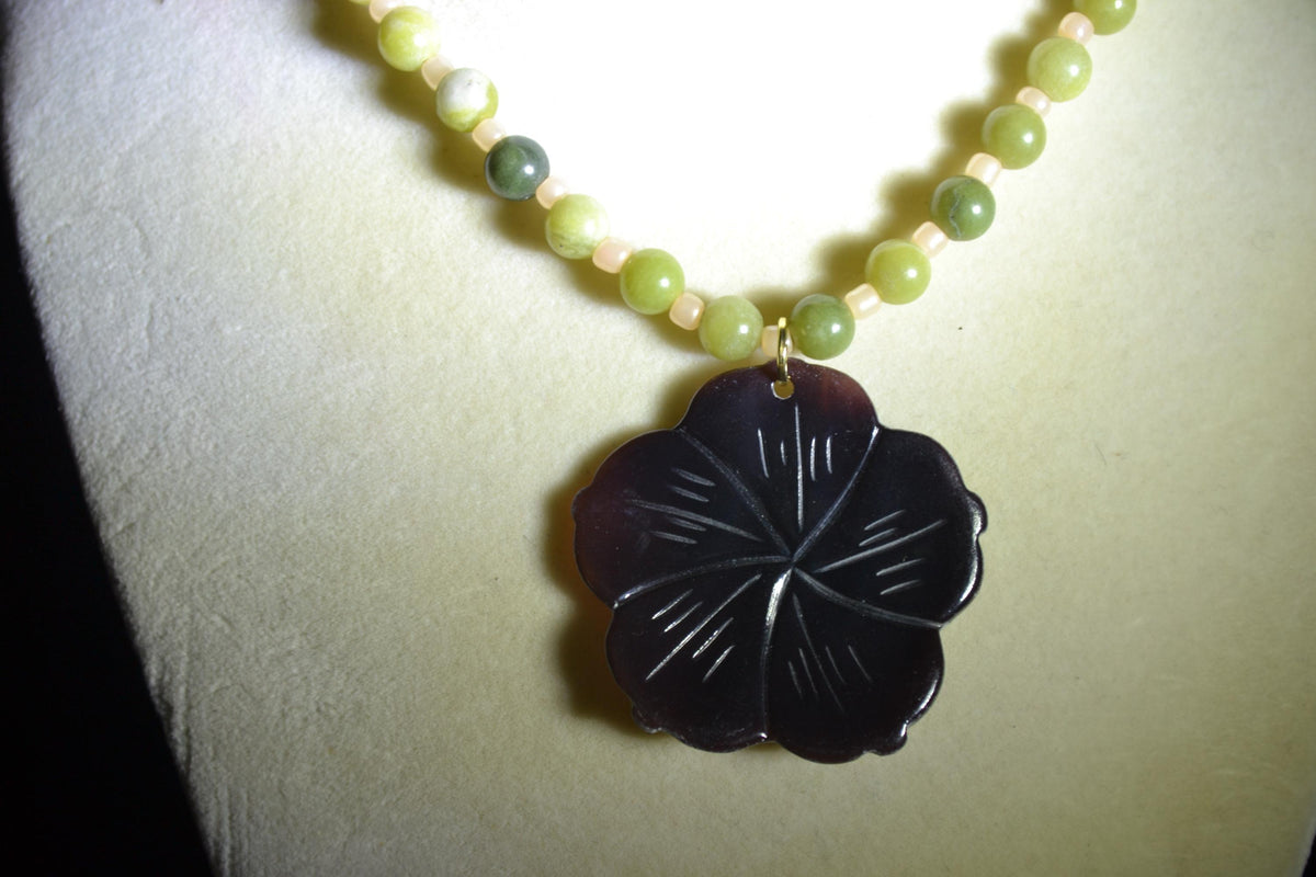 Carved Plumeria pendant glass bead necklace. Green jade and sand