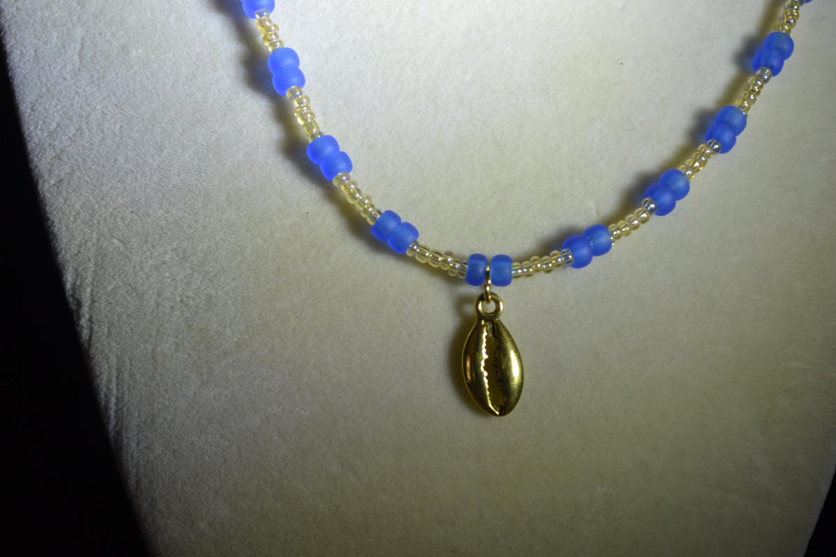 Gold Cowrie shell pendant glass bead necklace. Frosted blue and sand