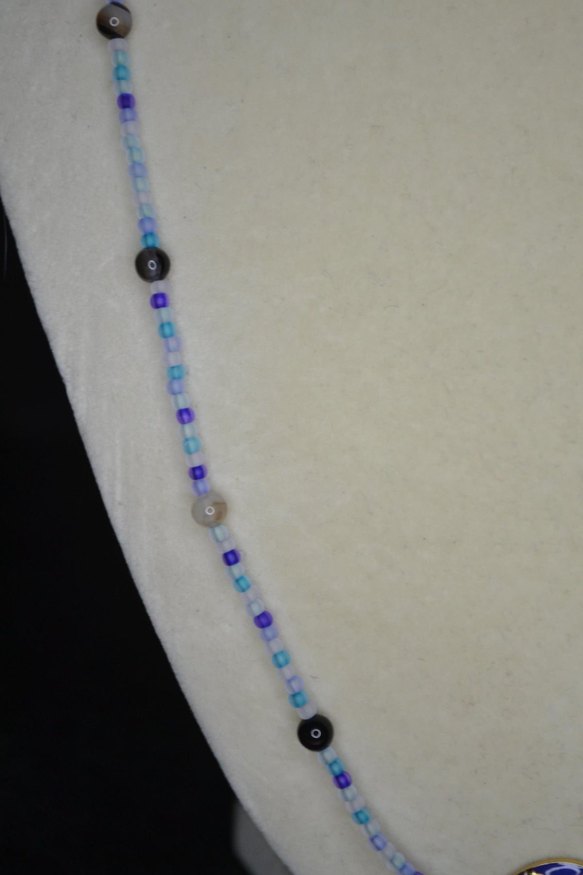 Gold Hummingbird pendant glass bead necklace. Blues and black agate