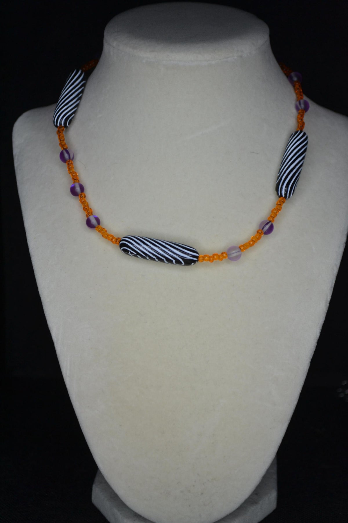 Multicolor glass and wood bead necklace. Orange, frosted purple, and black and white stripes