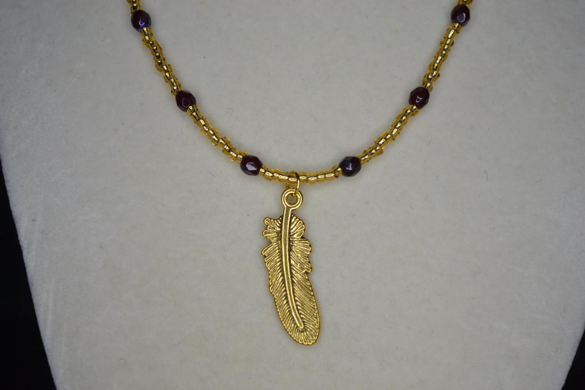 Gold feather pendant glass bead necklace. Garnet and gold. FSU