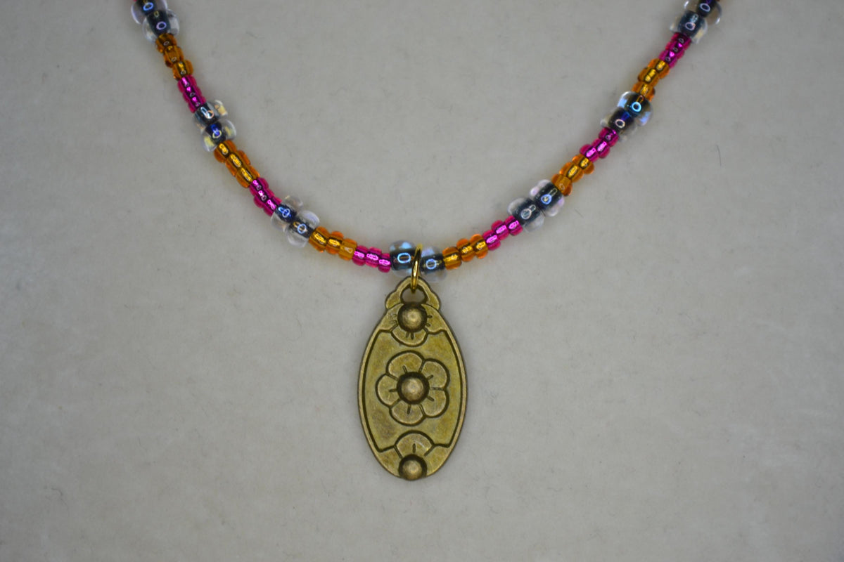 Bronze gold flower pendant glass bead necklace. Brown, Fuschia, and black