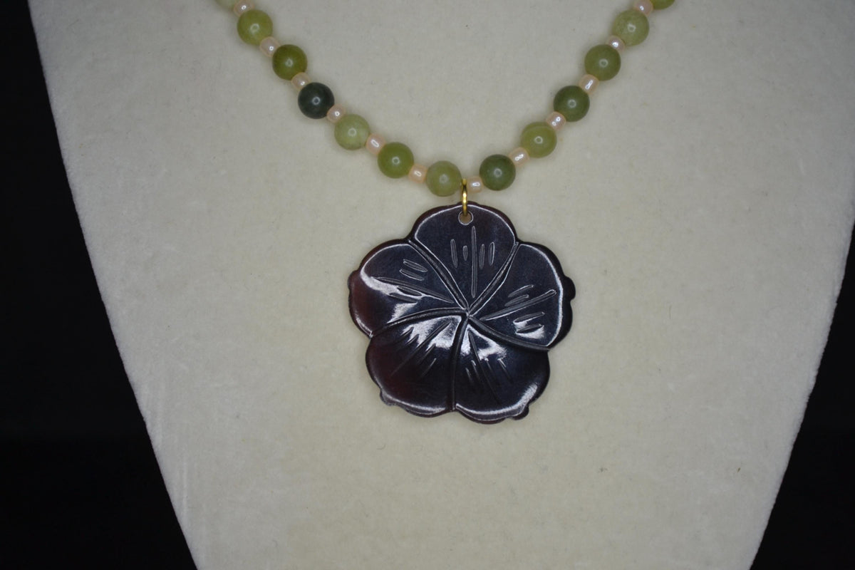 Carved Plumeria pendant glass bead necklace. Green jade and sand