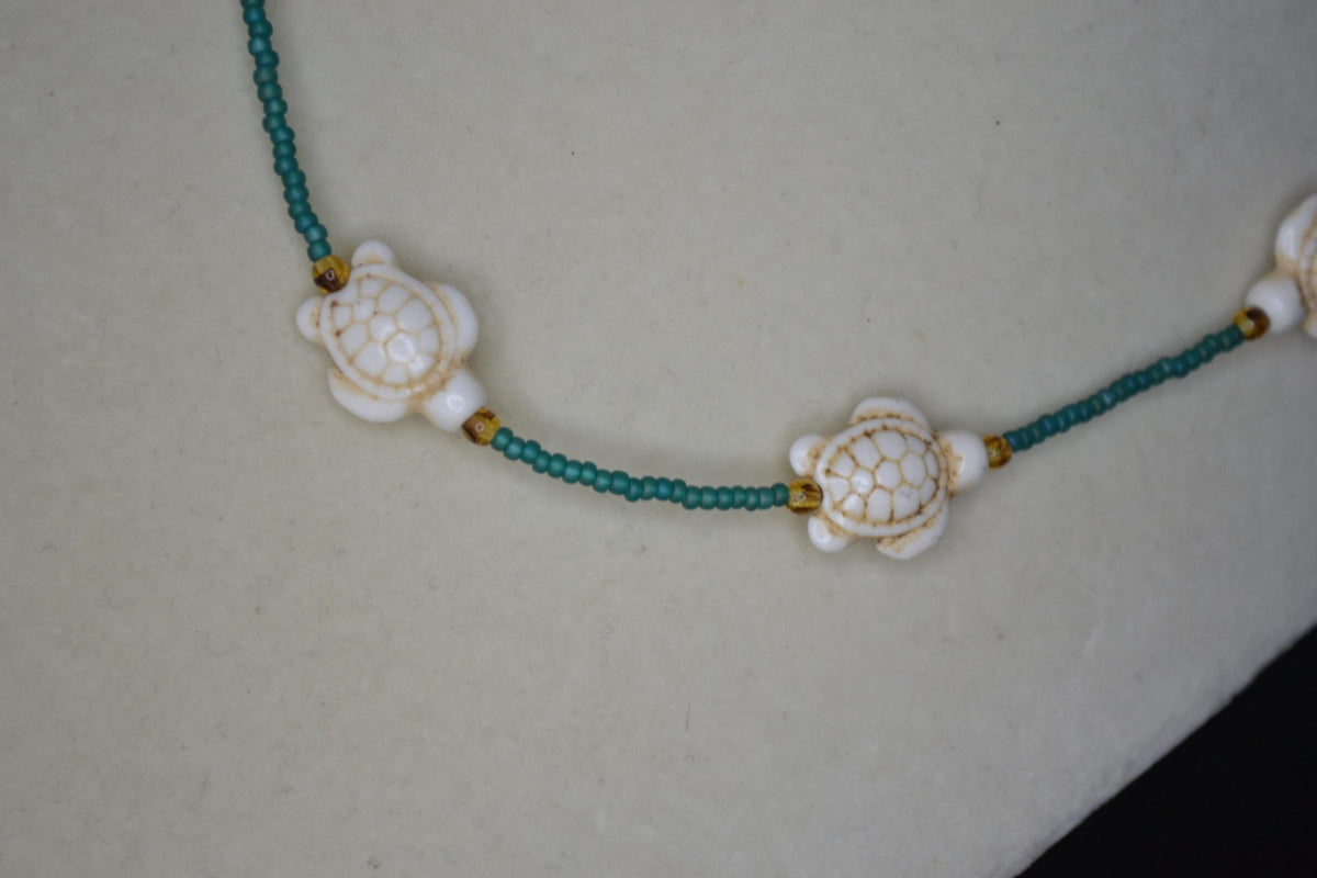 Multicolor glass bead necklace. White turtles, teal, and brown tortoise