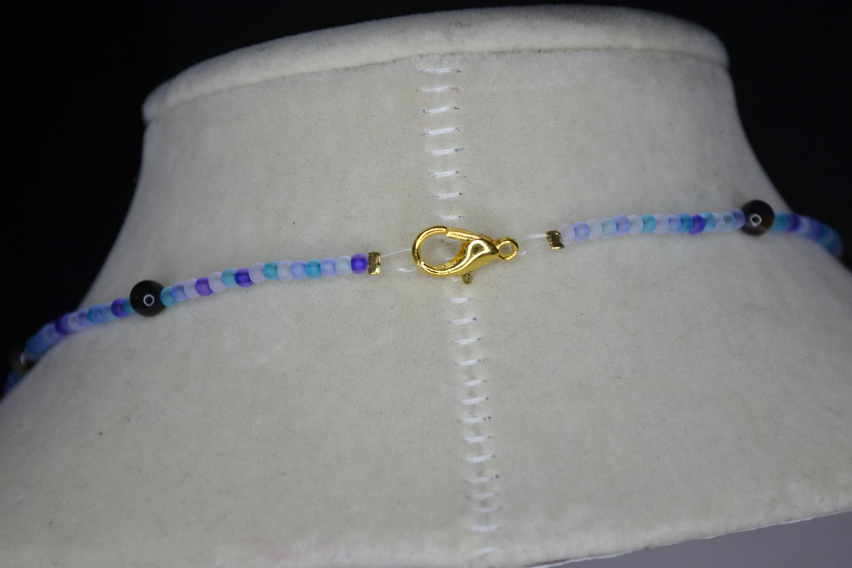 Gold Hummingbird pendant glass bead necklace. Blues and black agate