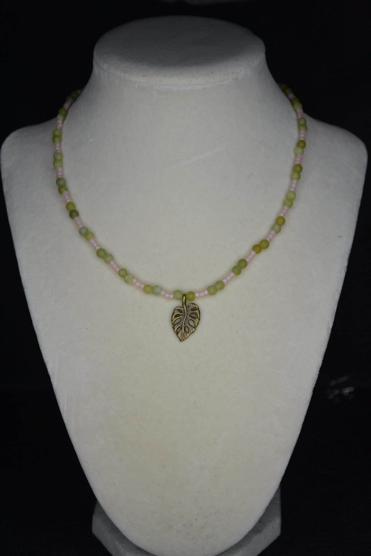Bronze monstera pendant glass bead necklace. Jade and frosted pink