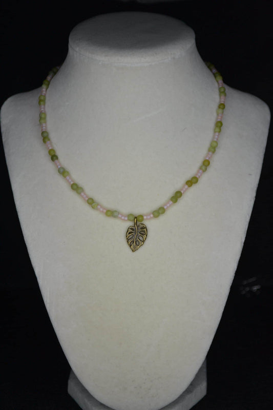 Bronze monstera pendant glass bead necklace. Jade and frosted pink