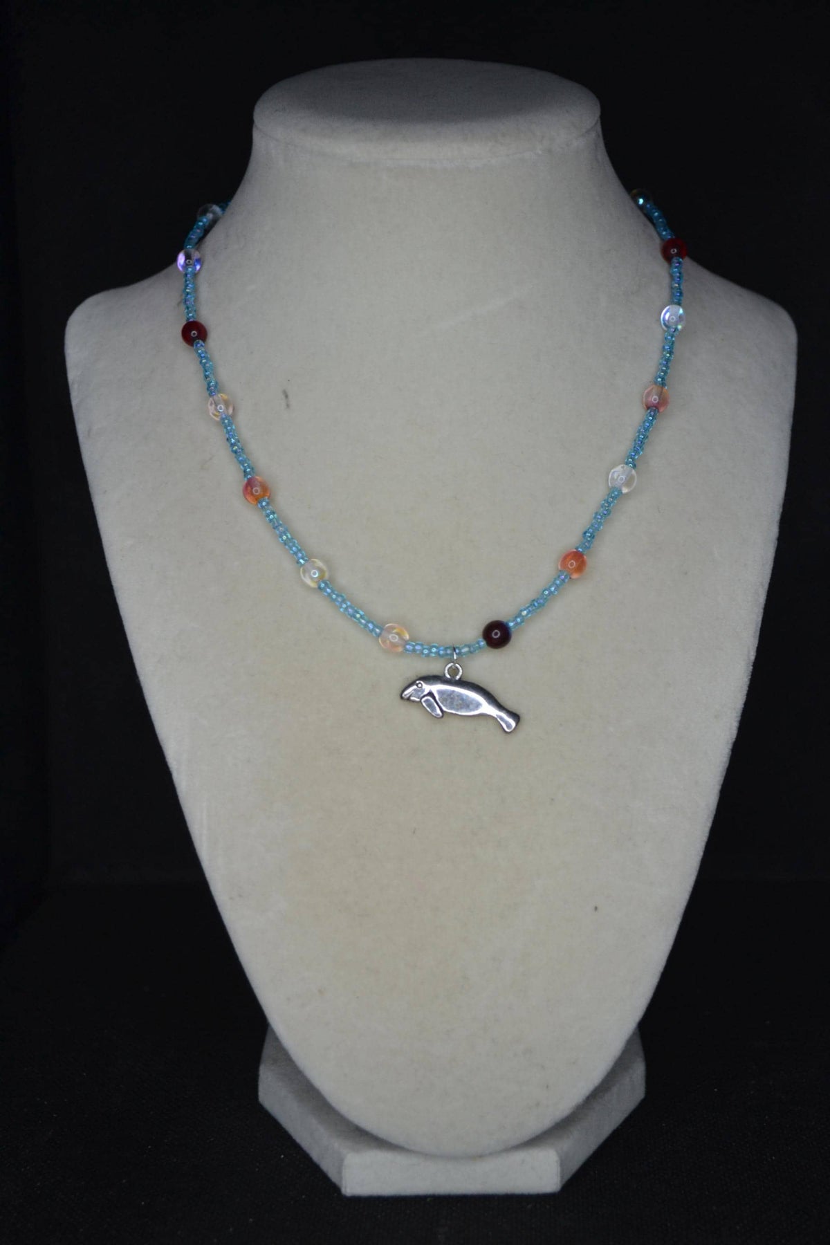 Silver Manatee pendant glass bead necklace. Blue and reds