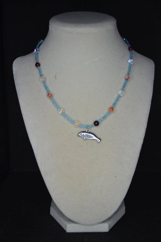 Silver Manatee pendant glass bead necklace. Blue and reds