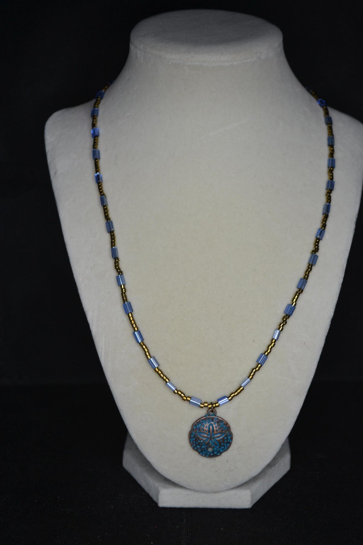 Bronze Sand dollar pendant glass bead necklace. Blue and bronze
