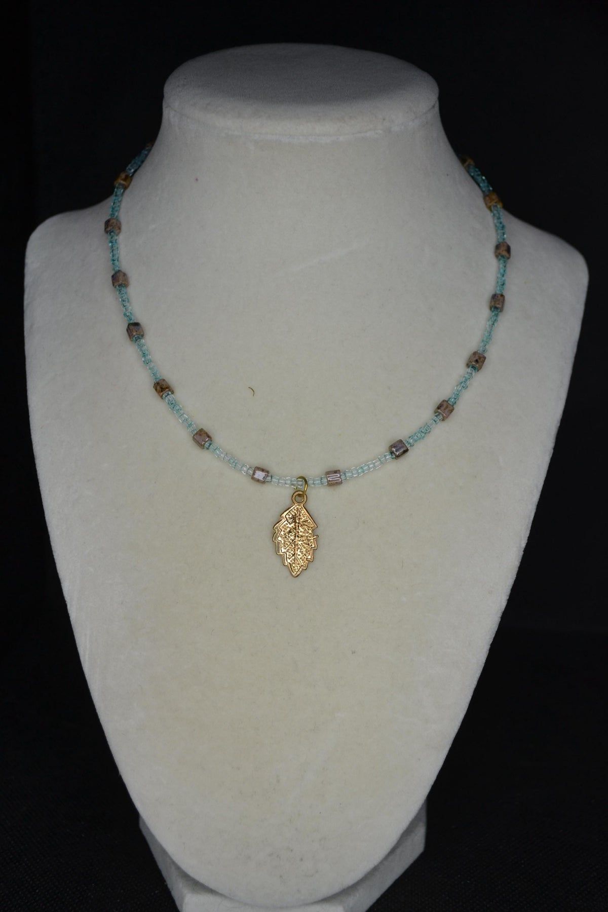 Feather pendant glass bead necklace. Teal and natural stone